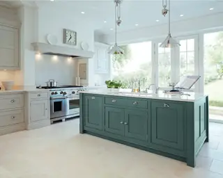 シェーカーキャビネットとクロムペンダントライトを備えたグレーのキッチンアイランド