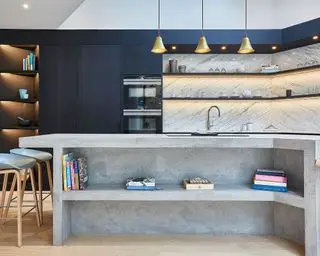 Cuisine avec armoires bleues, îlot en béton et éclairage LED