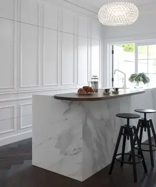 大理石のアイランドと黒いスツールを備えた白い隠しキッチン