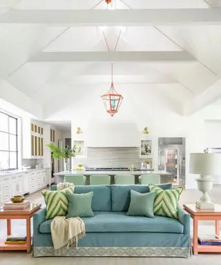 אזור מגורים במטבח עם ספה כחולה ופנס כתום ושולחן צד