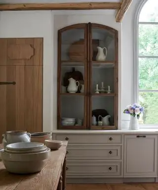 Rustikálna kuchyňa so starožitnými presklenými zakrivenými dvierkami nástennej skrinky