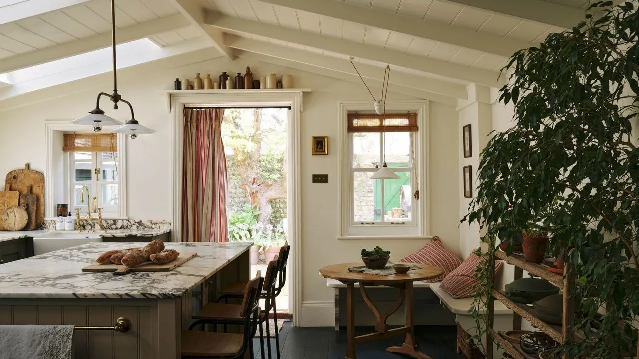 Une nouvelle extension de cuisine avec des plafonds voûtés, des armoires vert olive, des comptoirs en marbre et un coin repas confortable' loading='lazy' title=