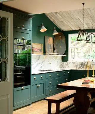 cuisine vert foncé avec plafond en bois et luminaires en laiton