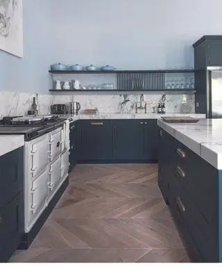 Idées de revêtement de sol de cuisine dans une cuisine bleue et en marbre avec parquet à chevrons.