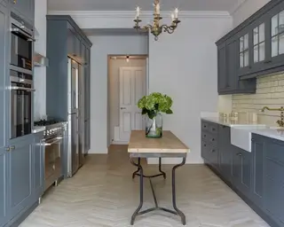 ブルーのユニット、温かみのある木の棚、石の上のアイランドを備えたモダンなキッチン