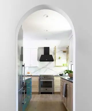 Cuisine américaine vue à travers une arcade avec armoires bleues et en bois