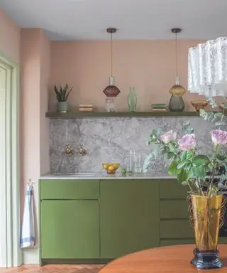Cuisine avec armoires vertes et murs roses