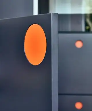 mám použiť úchytky alebo gombíky na kuchynské skrinky, detail modrej skrinky s oranžovým ťahom