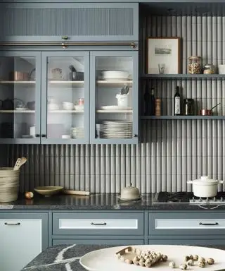 mám použiť rúčky alebo gombíky na kuchynských skrinkách, sivomodrú kuchyňu s presklenými skrinkami, ryhovanú stenu, otvorené police, kremennú dosku