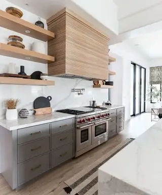 Cuisine grise avec armoires supérieures remplacées par des étagères ouvertes en bois