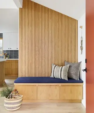 서랍이 있는 화이트 오크 수납 벤치, 파란색 겉천을 씌운 시트 쿠션, 뒤쪽 벽에 화이트 오크 슬레이트 패널을 갖춘 현대적인 출입구 벤치 아이디어