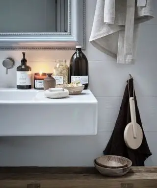 Rafinovaný sezónny dekor, zima. Detail jantárových sklenených fliaš a drevených riadov v kúpeľni so zapálenými sviečkami