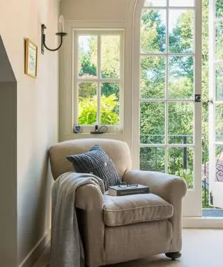 Uma poltrona perto da janela de um quarto.