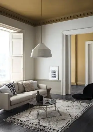 겨자색 천장과 대비되는 무채색 계열의 거실입니다.