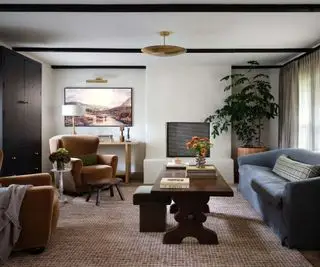 סלון עם ארון אחסון מובנה, קירות לבנים וקורות תקרה