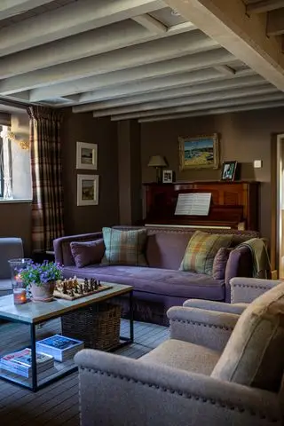 hyggelig lun hule med lilla sofa og creme lænestole og bjælkeloft