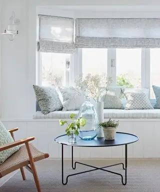 Salón blanco con asiento junto a la ventana