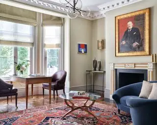 Salón luminoso con escritorio y sillas.