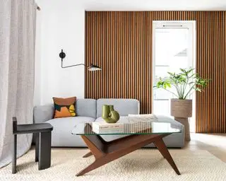 stue med biege teppe, midcentury salongbord, blå sofa og trepanel