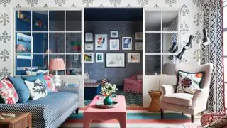 Un salon alcôve bleu avec mur galerie et mobilier bleu, crème et corail.