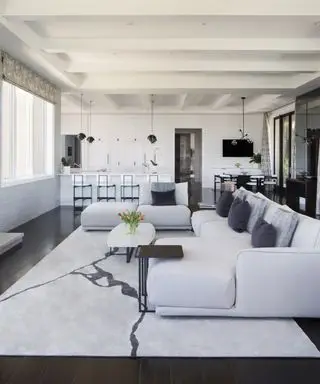 Ideias de feng shui para sala de estar - Uma sala de família branca em um espaço de estar e cozinha em plano aberto