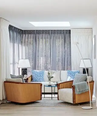 Salón costero con muebles suaves en azul y blanco.