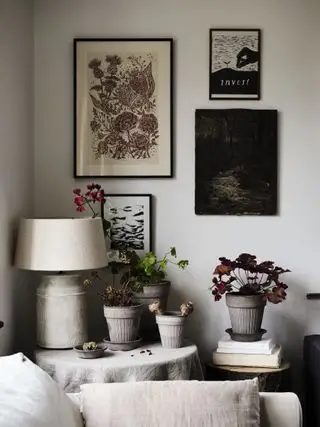 Esquina del salón con pared de galería y lámparas.