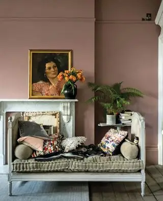 Ideen für die Bemalung Ihres Wohnzimmers in Sulking Room Pink von Farrow & Ball, mit einem vergoldeten Ölgemälde auf einem Steinkamin und einem weiß gestrichenen Vintage-Tagesbett.