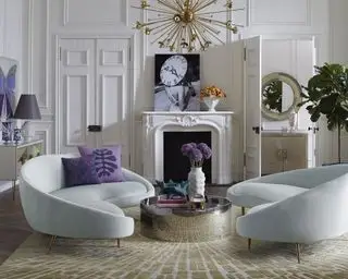 Formalne pomysły na salon z zakrzywionymi aksamitnymi sofami w kolorze pudrowego błękitu i kominkiem