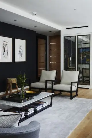 Salón contemporáneo en blanco y negro con suelo de madera y alfombra gris