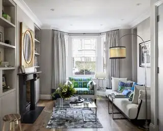 회색과 옅은 베이지색 소파, 녹색과 파란색으로 포인트를 준 전통적인 거실 아이디어입니다.