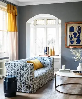 Ein Wohnzimmer mit blauer Tapete und gelben Akzenten