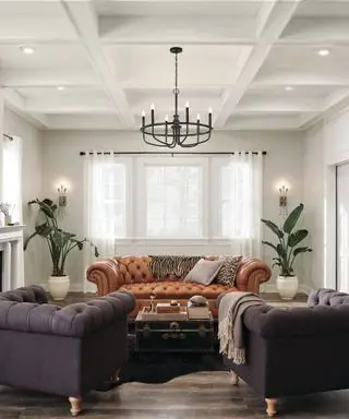 Como planejar a iluminação da sala com luminárias de parede Kichler, um sofá laranja e duas poltronas roxas