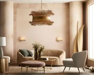 Lustre dourado nos interiores mostrando como planejar a iluminação da sala em um quarto rosa claro com móveis em tons pastéis.