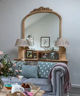 Lille stuebelysningsideer med to små stofbordlamper foran et stort forgyldt spejl.