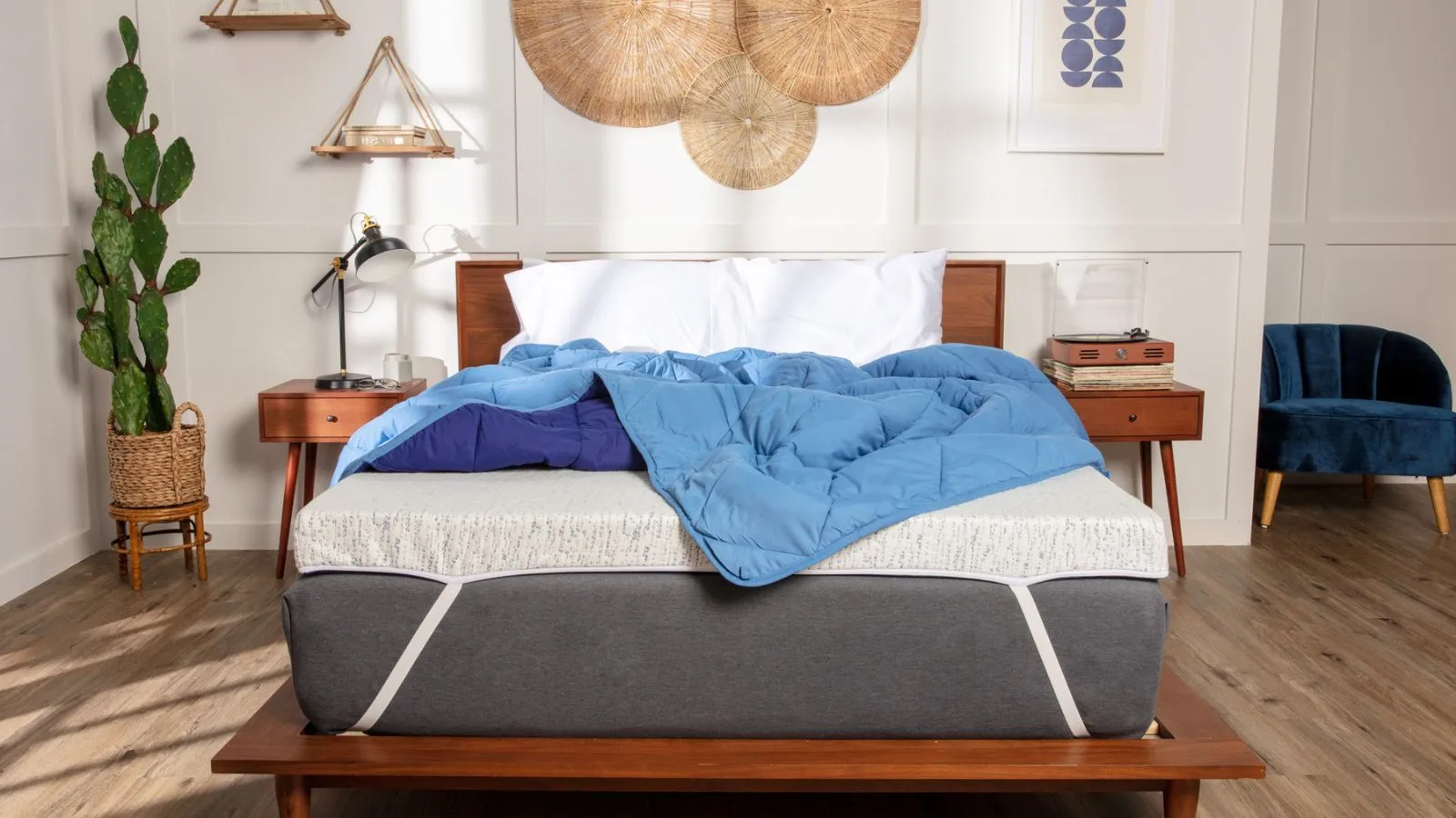 Soveværelse med en træseng, der viser madras topper og blå dyne' loading='lazy' title=
