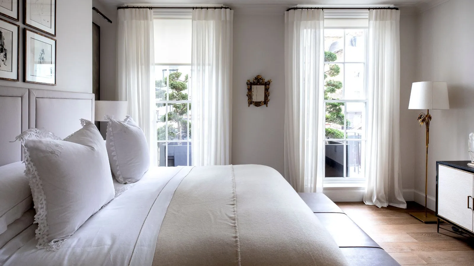 Soveværelse med hvide ark hvide frill puder og en taupe -dyne' loading='lazy' title=