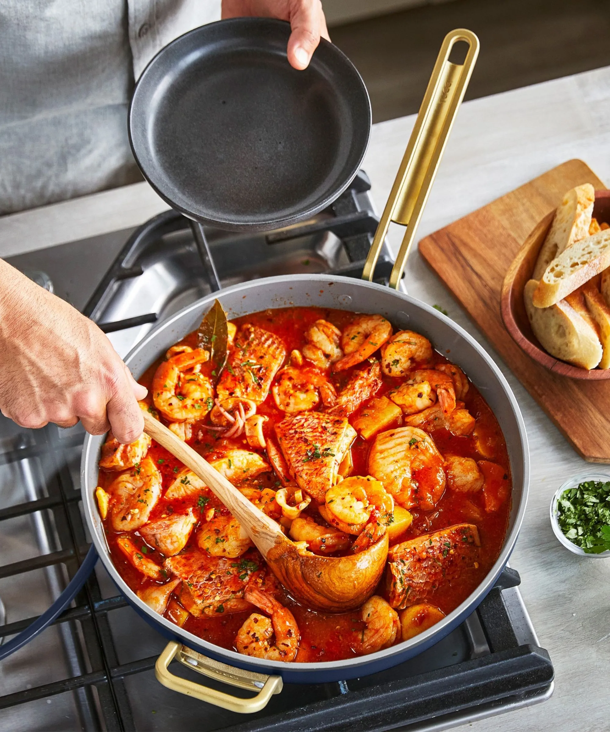 Modrozelená pánev obsahující dušené mořské plody' loading='lazy' title=