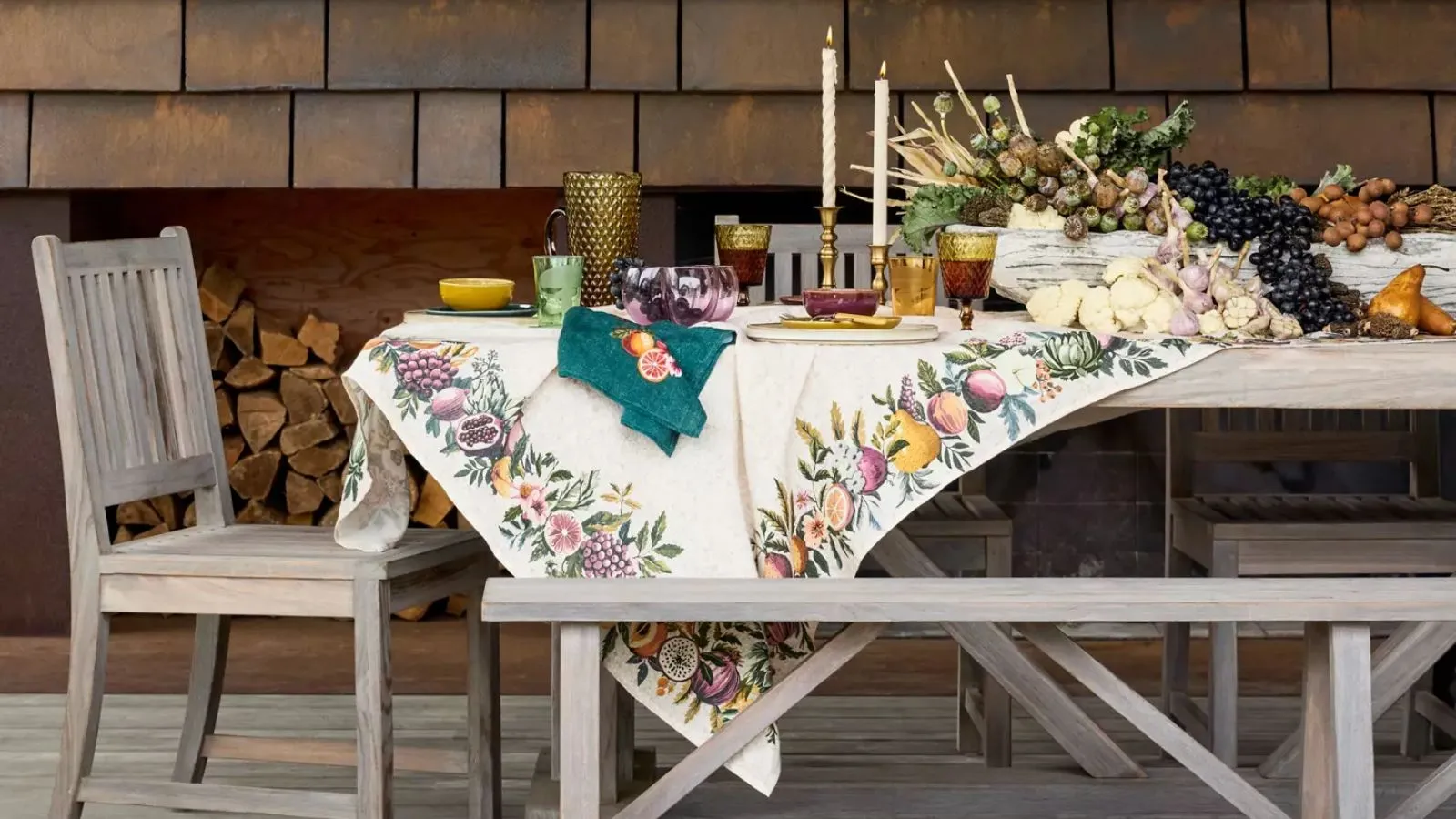 Mesa de Ação de Graças ao ar livre com toalha de mesa outonal com detalhes dourados e exibição de frutas' loading='lazy' title=