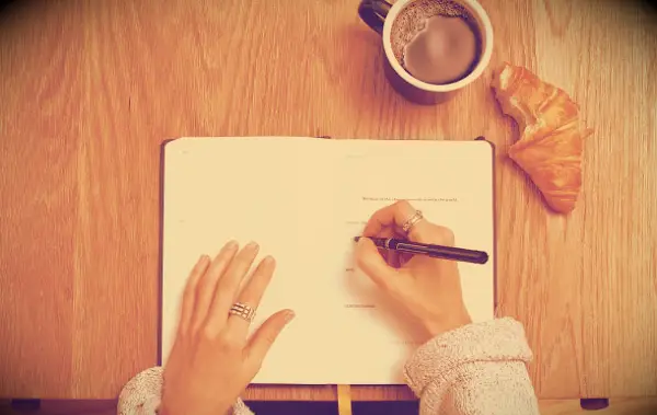 A woman writing in a notebook.