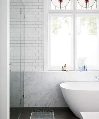 bagno con piastrelle bianche della metropolitana, marmo di Carrara e vasca freestanding progettata da Sarah McPhee in una casa d'epoca a Melbourne