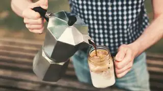 Une presse française versant du café sur un pot Kilner pour préparer du café glacé