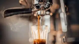 Un expresso dans un verre sous le porte-filtre d'une machine à expresso