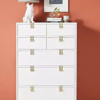 Anthropologie Ingram 7개의 서랍장이 복숭아색 벽에 붙어있습니다.