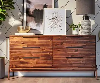 회색 벽 위에 장신구가 달린 브라운 Apt2B 서랍장.