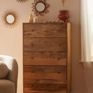 베이지색 벽에 기대어 있는 Urban Outfitters Amelia 톨 서랍장.