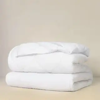 Coprimaterasso morbido su sfondo beige.