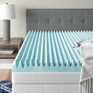 Cubrecolchón con forma de caja de huevos en la cama en una habitación elegante