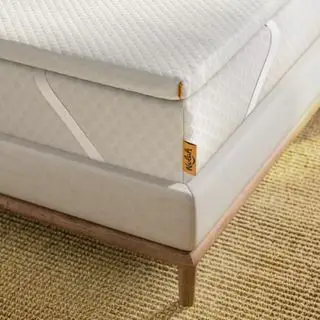 Coin d'un surmatelas Nolah sur un lit.
