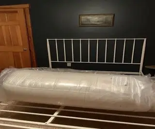 バーチ ラックス ナチュラル マットレスが青い壁のベッド フレームに包まれています。